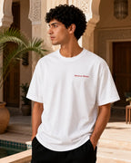 T-shirt blanc minimaliste MarocGear avec inscription Morocco Always, présenté dans un décor de riad marocain premium.