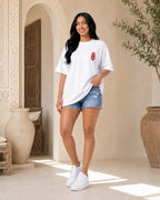T-shirt blanc MarocGear avec badge rouge marocain, porté dans un décor de riad premium.