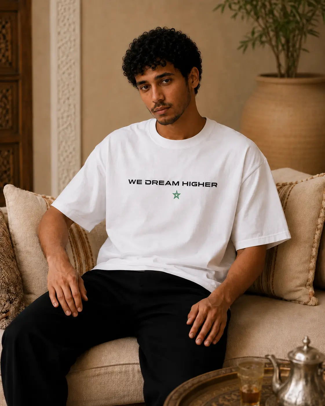 T-shirt blanc MarocGear Maroc 2026, design supporter avec slogan We Dream Higher et visuel premium dans un riad marocain.