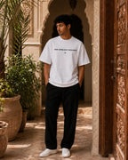 T-shirt blanc MarocGear Maroc 2026, design supporter avec slogan We Dream Higher et visuel premium dans un riad marocain.
