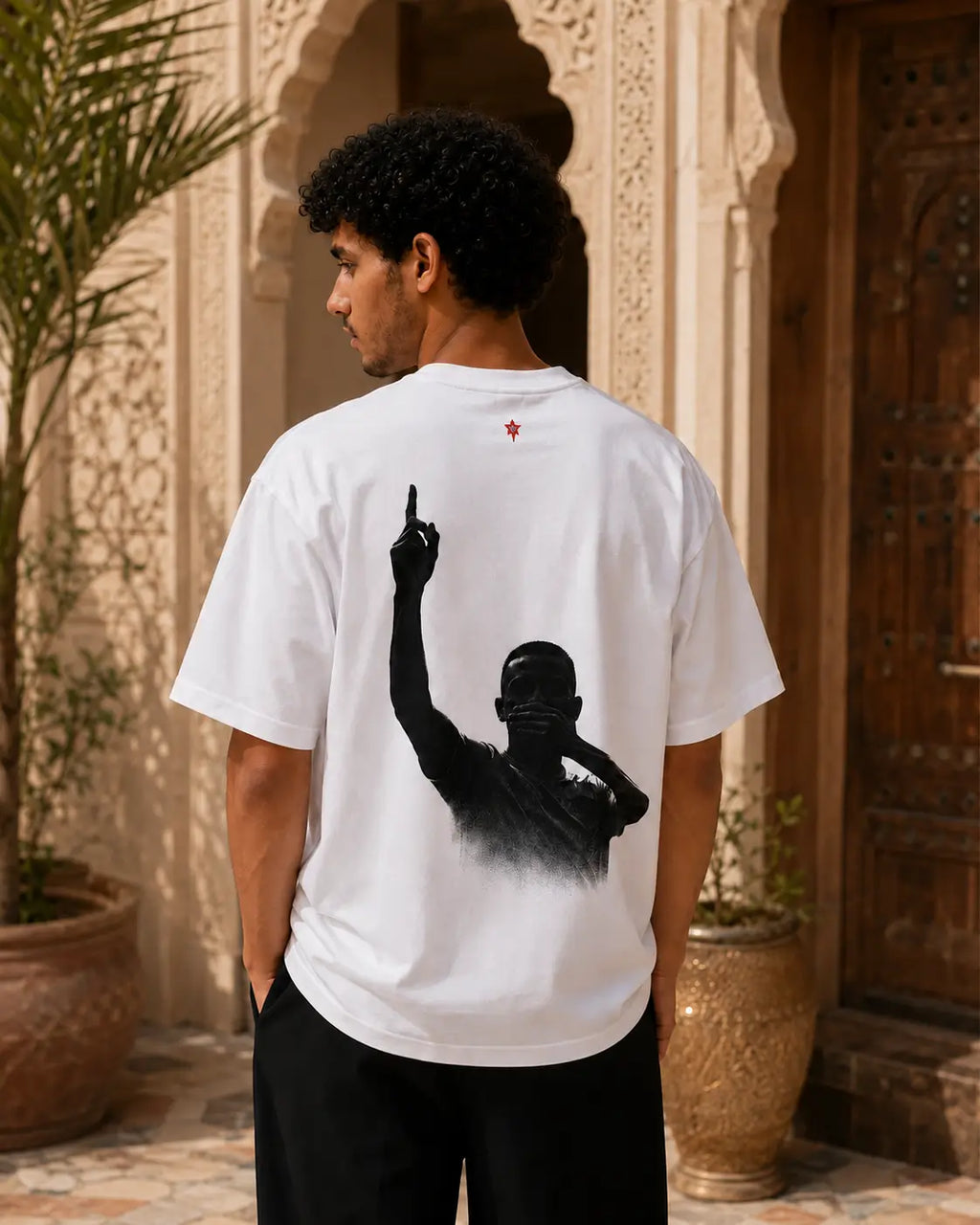 T-shirt blanc MarocGear Maroc 2026, design supporter avec slogan We Dream Higher et visuel premium dans un riad marocain.