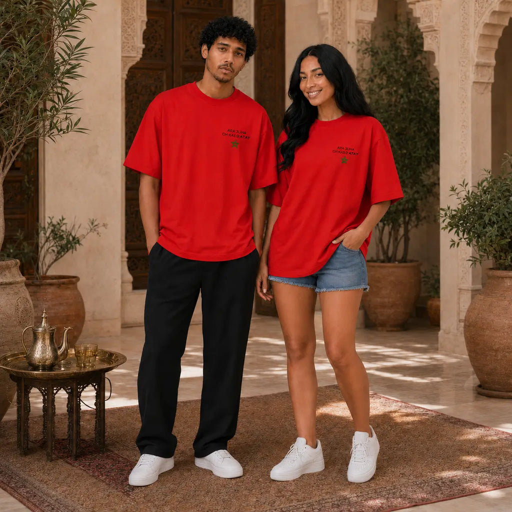 Deux modèles portent le t-shirt rouge MarocGear ATAY dans un riad marocain, avec design supporters du Maroc au dos et logo minimaliste à l’avant.