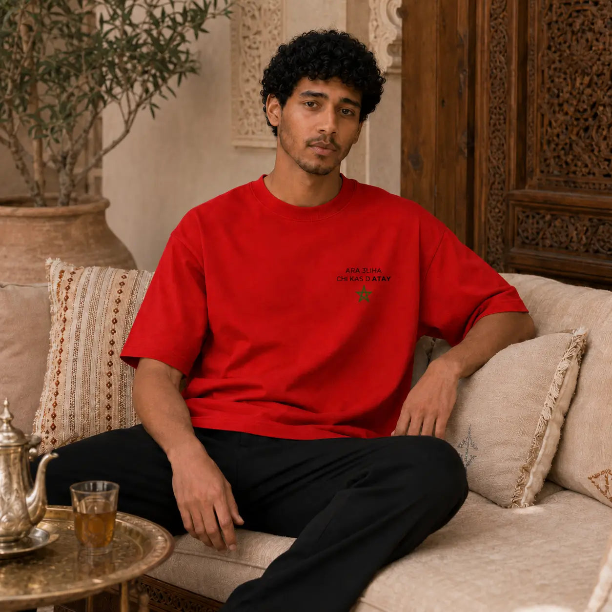 Deux modèles portent le t-shirt rouge MarocGear ATAY dans un riad marocain, avec design supporters du Maroc au dos et logo minimaliste à l’avant.